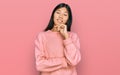 Beautiful young asian woman wearing casual winter sweater looking confident at the camera with smile with crossed arms and hand Royalty Free Stock Photo