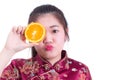 Beautiful Young asian woman wearing chinese dress traditional cheongsam or qipao. Pretty Girl Touching her Face with juicy orange Royalty Free Stock Photo