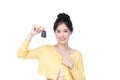 Beautiful young Asian woman wearing yellow shirt feeling happy and smile holding the keys of the car on white background Royalty Free Stock Photo