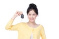 Beautiful young Asian woman wearing yellow shirt feeling happy and smile holding the keys of the car on white background Royalty Free Stock Photo