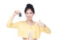 Beautiful young Asian woman wearing yellow shirt feeling happy and smile holding the keys of the car on white background Royalty Free Stock Photo