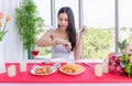 Beautiful young asian woman in white dress sitting waiting for her boyfriend in the restaurant