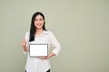Beautiful Asian woman holding a tablet mockup and showing thumb up Royalty Free Stock Photo