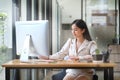 Beautiful young asian woman working with computer at bright modern office Royalty Free Stock Photo