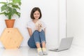 Beautiful young asian woman working on floor in living room at home with her maltese dog Royalty Free Stock Photo