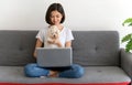 Beautiful young asian woman working on sofa at home with her maltese dog, Cheerful and nice couple with people and pet