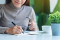 A beautiful young asian woman writing on a blank notebook on the table Royalty Free Stock Photo