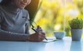 A beautiful young asian woman writing on a blank notebook on the table Royalty Free Stock Photo