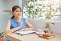 Beautiful young Asian woman writing to do list while sitting the window Royalty Free Stock Photo