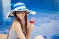 beautiful Young Asian women with beverages on summer party near the swimming pool .Happy girls in big hat and glasses relaxing Royalty Free Stock Photo