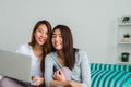 Beautiful young asian women LGBT lesbian couple sitting on sofa buying online using laptop a computer and credit card. Royalty Free Stock Photo