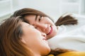 Beautiful young asian women LGBT lesbian happy couple hugging and smiling while lying together in bed under blanket at home. Royalty Free Stock Photo