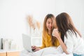 Beautiful young asian women LGBT lesbian happy couple sitting on bed hug and using laptop computer. Royalty Free Stock Photo