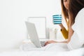 Beautiful young asian women LGBT lesbian happy couple sitting on bed hug and using laptop computer while drinking hot coffee cup. Royalty Free Stock Photo
