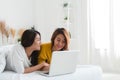 Beautiful young asian women LGBT lesbian happy couple sitting on bed hug and using laptop computer together bedroom at home. Royalty Free Stock Photo