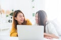 Beautiful young asian women LGBT lesbian happy couple sitting on bed hug and using laptop computer together bedroom at home. Royalty Free Stock Photo