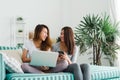 Beautiful asian women LGBT lesbian couple sitting on sofa buying online using laptop and phone in living room at home. Royalty Free Stock Photo