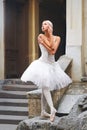 Beautiful ballerina dancing near an old building