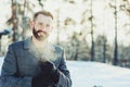 Beautiful young bearded men relaxing on winter walk in snowy forest, candid capture Royalty Free Stock Photo