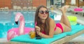 Beautiful young bikini woman in summer drinking a cocktail. Girl relaxing in tropical swimming pool. Portrait of young Royalty Free Stock Photo