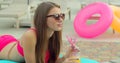 Beautiful young bikini woman in summer drinking a cocktail. Girl relaxing in tropical swimming pool. Portrait of young Royalty Free Stock Photo