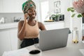 Black African traditional woman working from home wearing headscarf Royalty Free Stock Photo