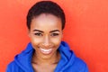 Beautiful young black fashion woman smiling against red wall