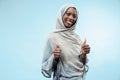The beautiful young black muslim girl wearing gray hijab, with a happy smile on her face.