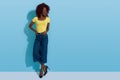 Happy Young Black Woman Is Standing Against Blue Wall, Looking Away And Laughing Royalty Free Stock Photo