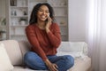 Beautiful young black woman talking on mobile phone at home and smiling Royalty Free Stock Photo