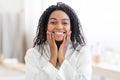 Beautiful young black woman touching her face and smiling at camera Royalty Free Stock Photo