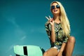 Beautiful young blond model girl in summer hipster clothes with skateboard Royalty Free Stock Photo