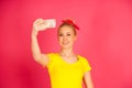 Beautiful young blond teenage woman in yellow t shirt taking se Royalty Free Stock Photo