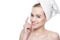 Beautiful Young Blond Woman applying Face cream under her eyes. Facial treatment. Royalty Free Stock Photo