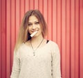 Beautiful young blond woman with chewing gum on the lips posing near red wall. Outdoor Royalty Free Stock Photo