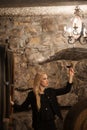 Beautiful young blond woman drinks wine in wine cellar Royalty Free Stock Photo