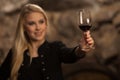 Beautiful young blond woman drinks wine in wine cellar Royalty Free Stock Photo