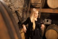 Beautiful young blond woman drinks wine in wine cellar Royalty Free Stock Photo