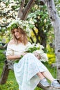 Beautiful young blond woman in lilac wreath on a swing