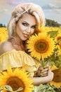 Beautiful young woman in a field of sunflowers in a yellow dress Royalty Free Stock Photo