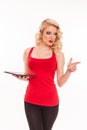 Beautiful young blond woman in red t-shirt holding a tablet comp