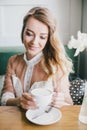 Beautiful young blond woman in a white dress enjoying coffee cappuccino with foam Royalty Free Stock Photo