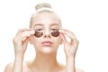 Beautiful young blonde with blue eyes is putting on or removing eye patches on a white background close-up isolated. Masks and fac