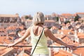 Beautiful young blonde girl on a background of blurred panoramic cityscape. Dubrovnik