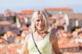 Beautiful young blonde girl on a background of blurred panoramic cityscape. Dubrovnik