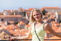 Beautiful young blonde girl on a background of blurred panoramic cityscape. Dubrovnik