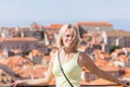 Beautiful young blonde girl on a background of blurred panoramic cityscape. Dubrovnik