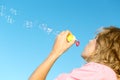 Beautiful young blonde girl blowing soap bubbles Royalty Free Stock Photo