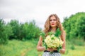 A beautiful young blonde girl collected a bouquet of wildflowers. Enjoy a walk on a warm summer day Royalty Free Stock Photo