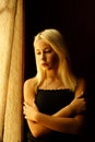 Beautiful young blonde girl. Dramatic portrait of a woman in the dark. Dreamy female look in twilight. Female silhouette